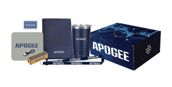 Apogee Charged for Success welcome kit with portable charger, journal, tumbler, lanyards, and branded box
